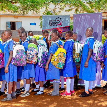 Ugandan schoolgirls proudly wearing Ecojua Smart Bags distributed by Smart Girls Uganda to promote education, menstrual health, and sustainability in off-grid communities.
