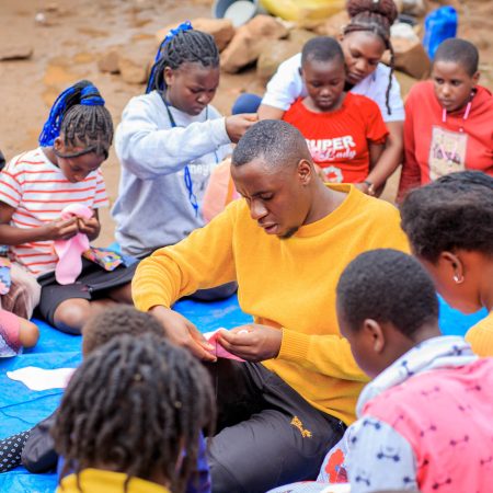 Young participants at a Smart Girls Uganda workshop learning to make reusable menstrual pads, part of the Ecojua Smart Bag program promoting menstrual health, vocational skills, and sustainability.