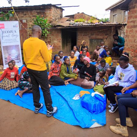 Community workshop led by Smart Girls Uganda on menstrual health and sustainability, with young women and girls gathered to learn about the Ecojua Smart Bag and reusable menstrual kits.