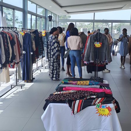 People browsing pre-loved clothing at a La Dame Qui Range resale event in Côte d’Ivoire, highlighting the social enterprise’s circular economy model and sustainable fashion initiatives.