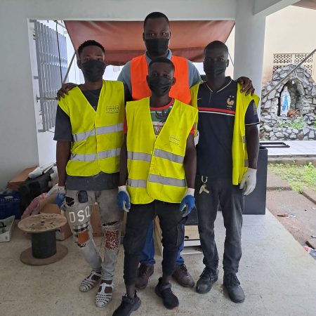 Team members of La Dame Qui Range in Côte d’Ivoire wearing branded safety vests during an organizing and recycling project, representing the woman-led social enterprise promoting sustainable organizing and circular economy practices.